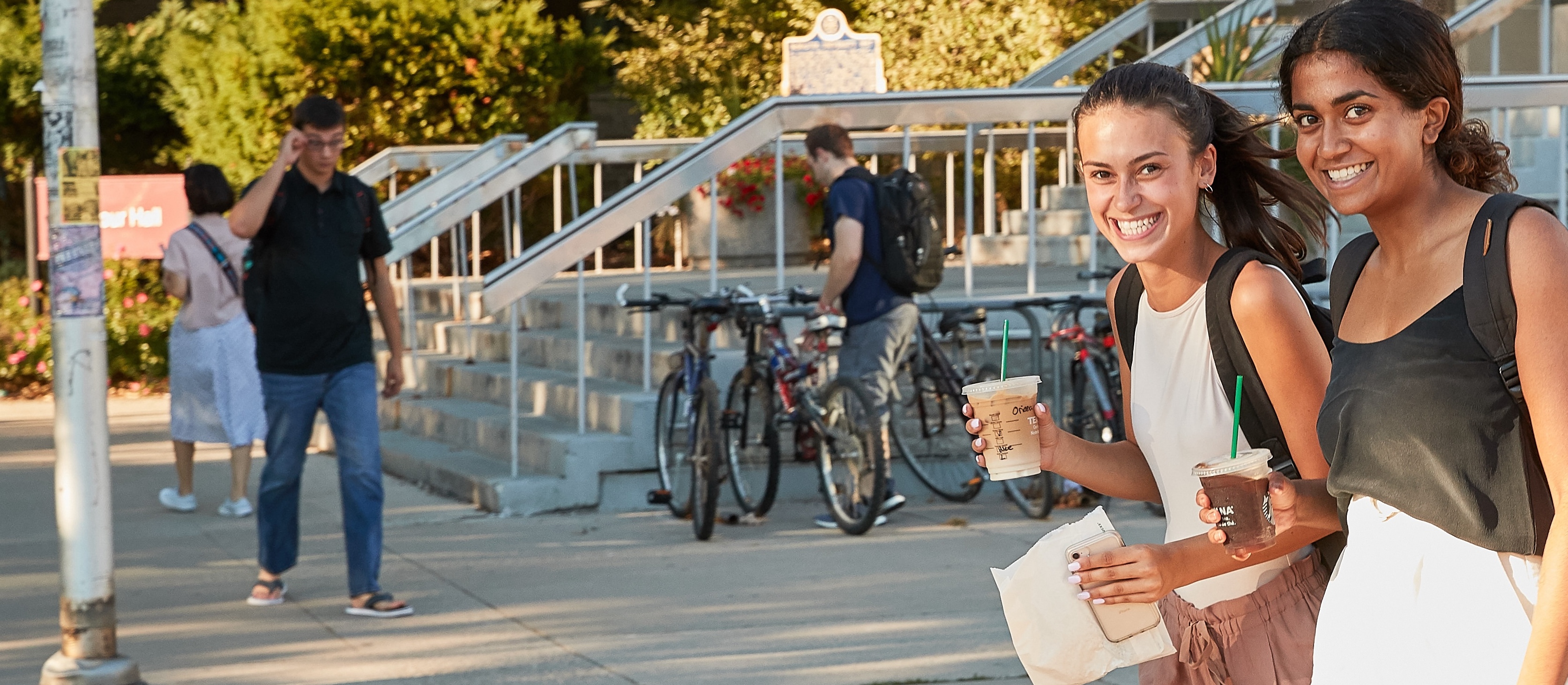 Students smiling as they walk across campus